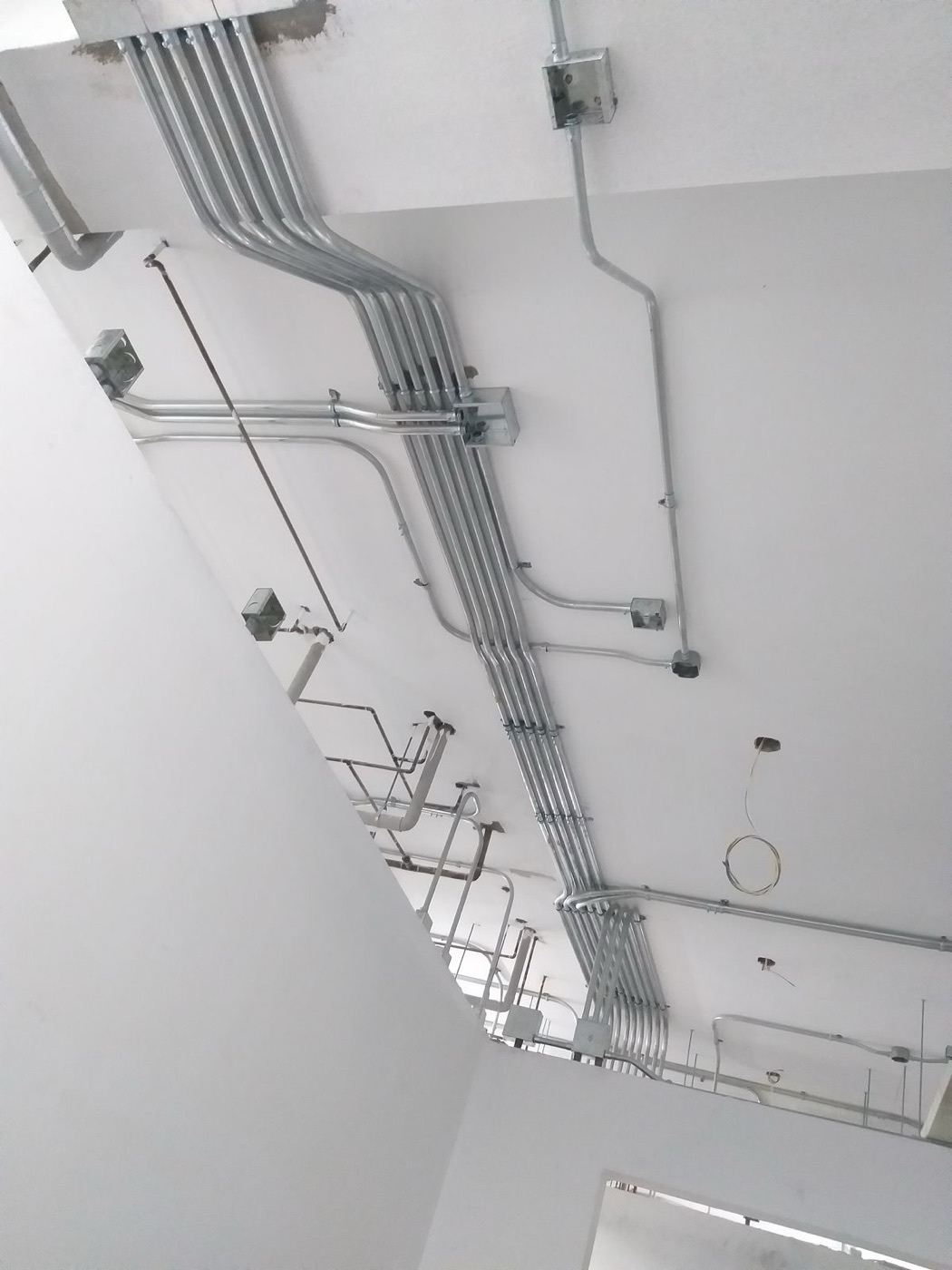 Múltiples tuberías eléctricas EMT conducidas a caja de conexión en cielo raso