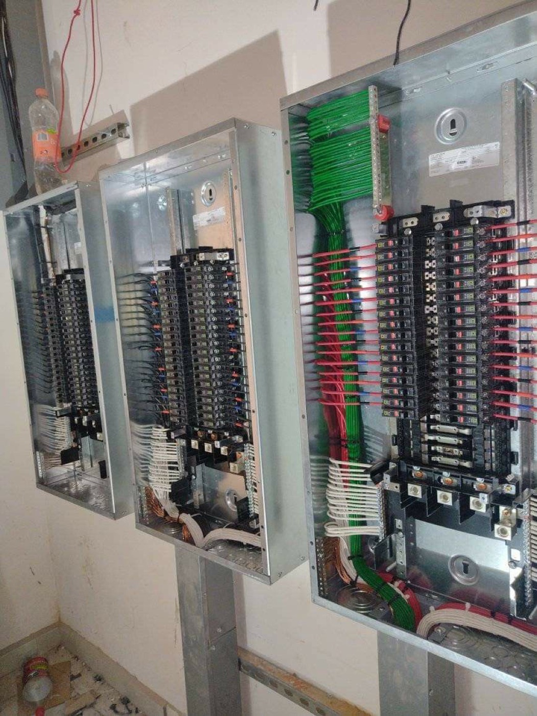 Paneles eléctricos montados en pared con cableado organizado por circuito